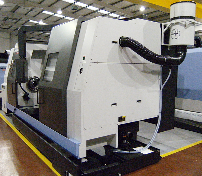 Nebbie oleose generate da macchine utensili CNC in ambiente di lavorazione meccanica industriale